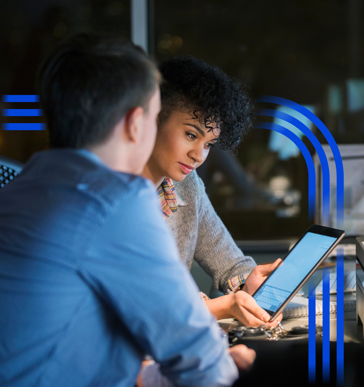 Two colleagues reviewing information together on a tablet in a modern office
